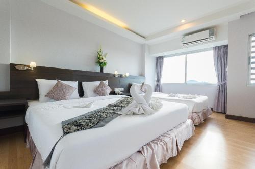 Ένα ή περισσότερα κρεβάτια σε δωμάτιο στο SinKiat Buri Hotel