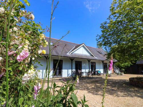 an old white house with flowers in front of it at The Coach House in Ryde
