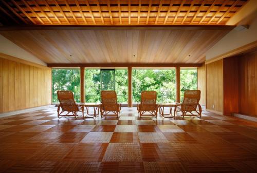 a room with a table and chairs and windows at Suimeikan in Gero