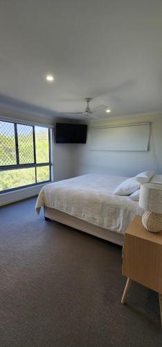 a bedroom with a large bed and a large window at Starfish Beach House in Agnes Water