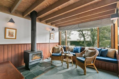 a living room with a couch and a wood stove at Magpies Nest in Thredbo