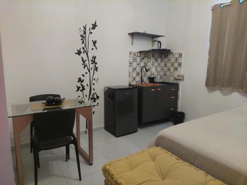 a bedroom with a desk and a bed and a kitchen at Kitnet Vila Marcela 1 in Petrolina