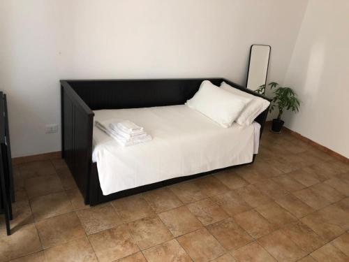 a bed with a black headboard and white sheets at RADICl BUSSI in Bussi sul Tirino