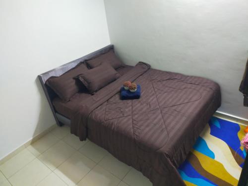 a small bed in a bedroom with a brown bedspread at Dkyra homestay teluk kemang in Port Dickson