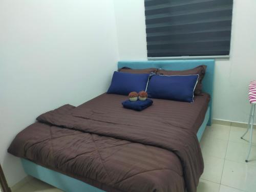a bed with blue pillows at Dkyra homestay teluk kemang in Port Dickson