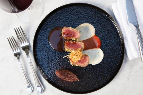 a black plate with food on a table at Sanasaryan Han, a Luxury Collection Hotel, Istanbul in Istanbul