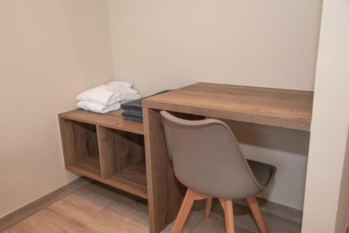 a desk with a white chair next to a table at Kaiser Luxury Suites in Achílleion