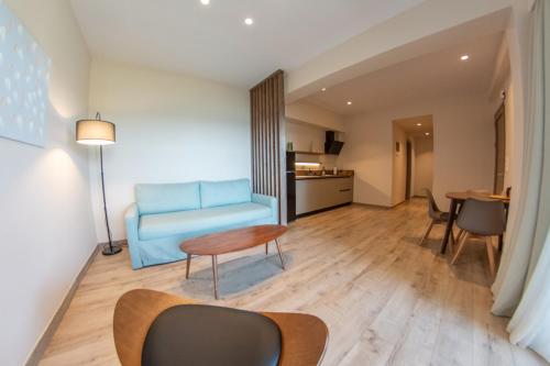 a living room with a blue couch and a table at Kaiser Luxury Suites in Achílleion