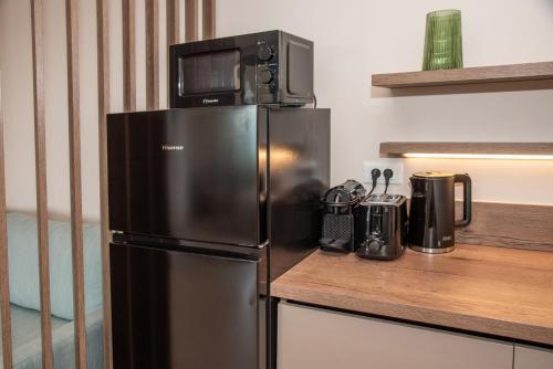 a microwave sitting on top of a refrigerator in a kitchen at Kaiser Luxury Suites in Achílleion