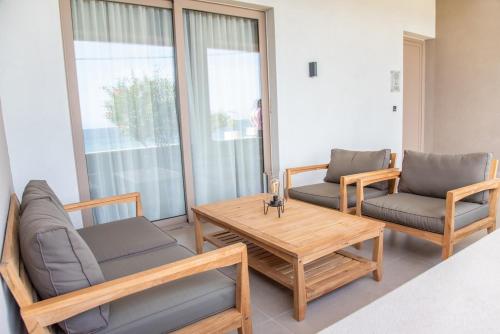 a living room with two chairs and a table and a couch at Kaiser Luxury Suites in Achílleion