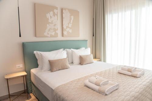 a bedroom with a large bed with two towels on it at Kaiser Luxury Suites in Achílleion