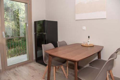 a dining room with a table and a refrigerator at Kaiser Luxury Suites in Achílleion