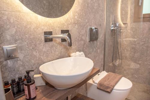 a bathroom with a sink and a toilet and a shower at Kaiser Luxury Suites in Achílleion