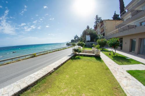 an empty street in front of a building with the ocean at Kaiser Luxury Suites in Achílleion
