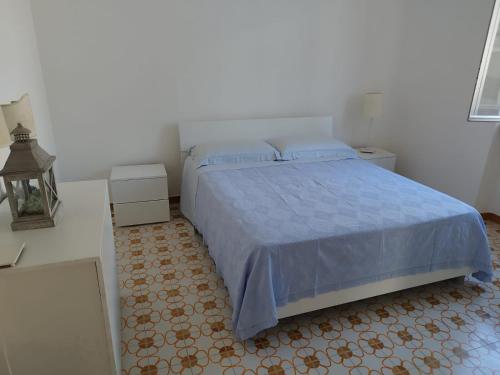 a bedroom with a bed with a blue comforter at Casa Archi Santa Cesarea Terme in Santa Cesarea Terme
