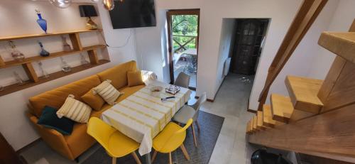 Una sala de estar con una mesa y sillas amarillas. en Domek Augustówka, en Świeradów-Zdrój