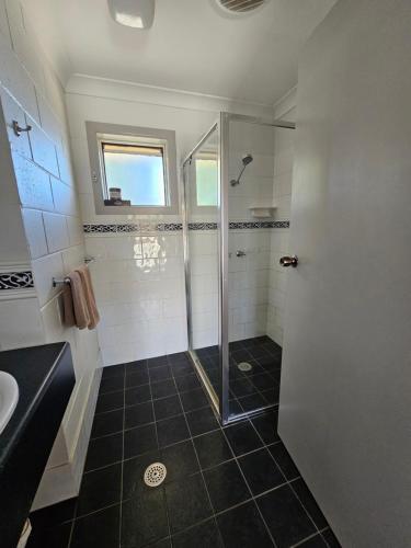 a bathroom with a shower and a glass door at Bellview Motel in Narrabri