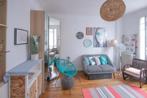 un salon avec un canapé et une chaise dans l'établissement Joséphine Baker , appartement cosy , 2 pièces ensoleillé, à Paris