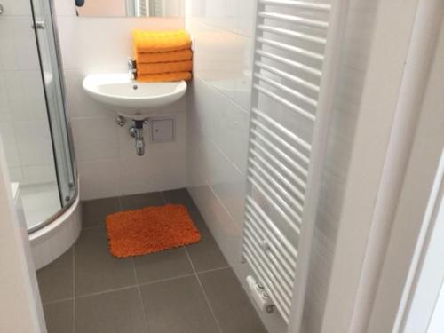 biała łazienka z umywalką i prysznicem w obiekcie Apartment opera w Wiedniu