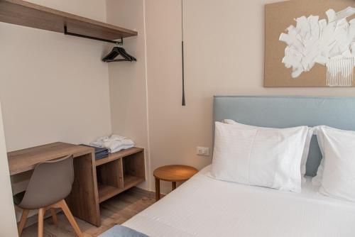 a bedroom with a bed with a desk and a bed sidx sidx sidx at Kaiser Luxury Suites in Achílleion