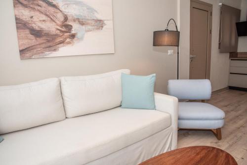 a living room with a white couch and a chair at Kaiser Luxury Suites in Achílleion