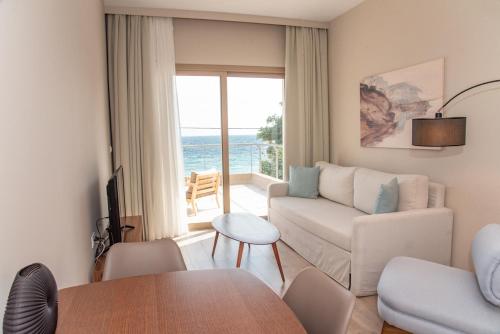 a living room with a couch and a table at Kaiser Luxury Suites in Achílleion