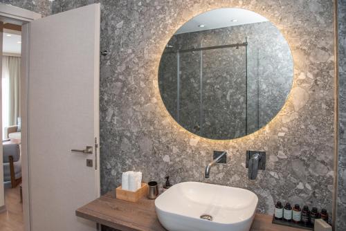 a bathroom with a sink and a mirror on the wall at Kaiser Luxury Suites in Achílleion