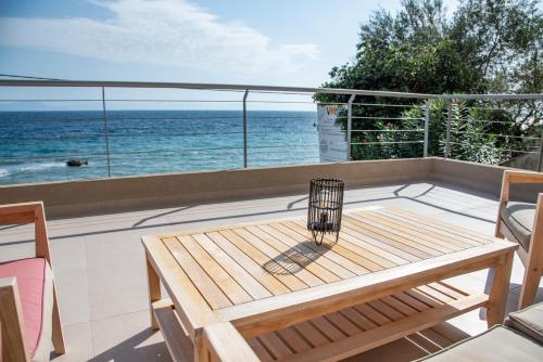 a balcony with a table and a view of the ocean at Kaiser Luxury Suites in Achílleion