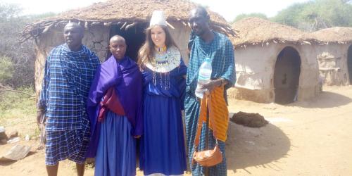 a group of people standing in front of a hut at SURUNGAI EMANYATA Maasai Boma in Arusha