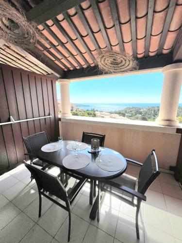 une salle à manger avec une table et des chaises et une grande fenêtre dans l'établissement Village Cap Esterel Vue Mer, Duplex Climatisé, à Agay