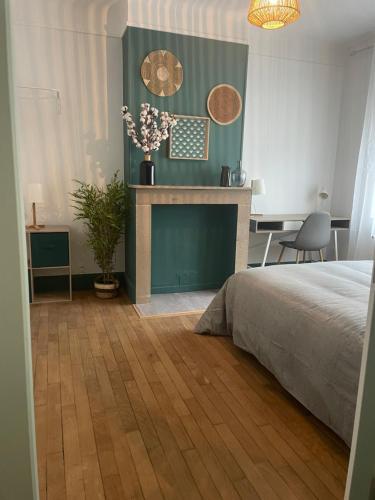 une chambre avec un lit et une cheminée dans l'établissement Appartement calais nord, à Calais