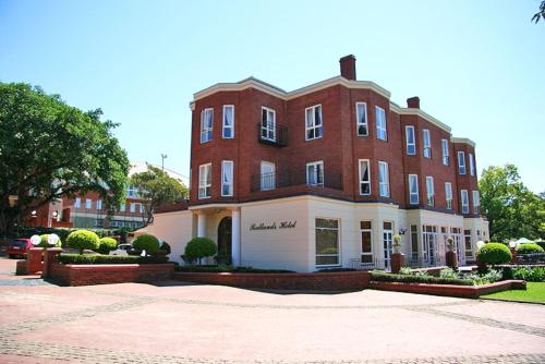 un gran edificio de ladrillo frente a un edificio en Redlands Hotel, en Pietermaritzburg