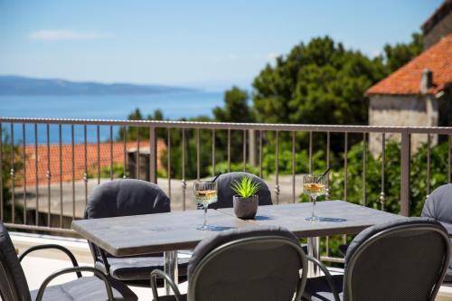a table with glasses of wine on a balcony at Villa Filia in Tučepi