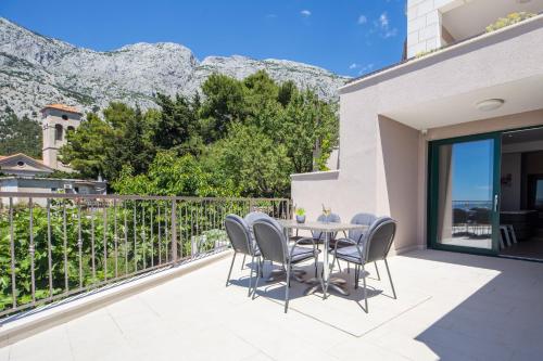 a patio with a table and chairs with mountains in the background at Villa Filia in Tučepi