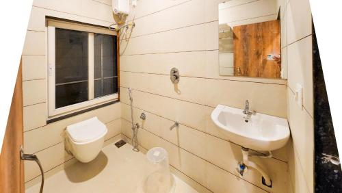 a bathroom with a toilet and a sink at Hotel Nova Shine in Rajkot