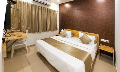 a bedroom with a bed and a table and a desk at Hotel Nova Shine in Rajkot