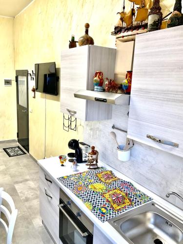 a kitchen with a sink with a mosaic counter top at Eruption1669 in Catania