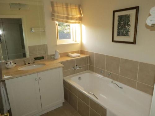 a bathroom with a tub and a sink at Redlands Hotel in Pietermaritzburg