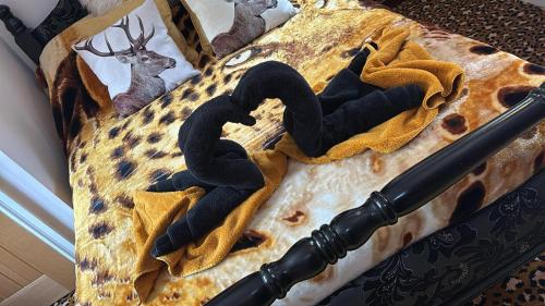 a bed with a blanket with two snakes on it at Willow's Cottage in Edwinstowe