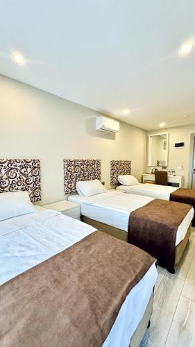 a hotel room with three beds in a room at Toprak City Hotel Antalya in Antalya