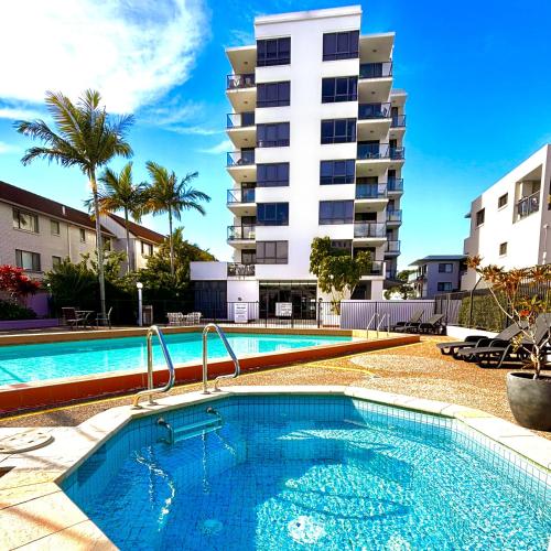a swimming pool in front of a apartment building at Aqualine Apartments On The Broadwater in Gold Coast