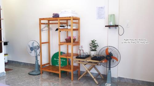 a book shelf with a fan and a fan at Người Măng Đen Homestay in Kon Von Kla