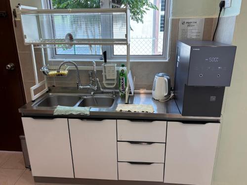 a kitchen counter with a sink and a microwave at Duyong Damai Homestay by KOWBMAS in Melaka
