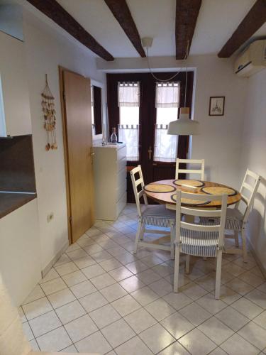 Una cocina y un comedor con mesa y sillas. en Piran Nono, en Piran