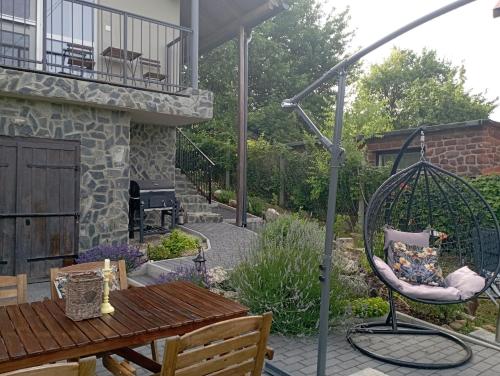 a garden with a swing and a table and a patio at Vulcanus Apartment in Badacsonytomaj