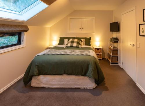 a bedroom with a bed and a skylight at The Loft at Sixty-7 in Queenstown