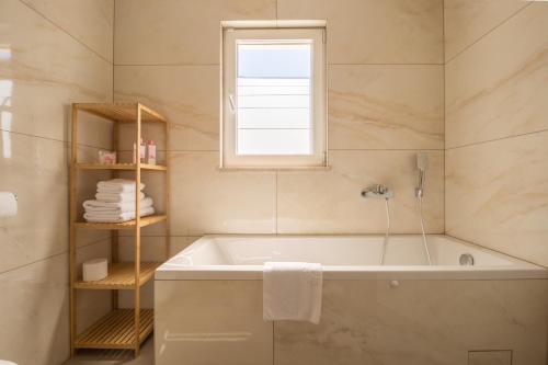 a bathroom with a bath tub and a window at Villa Filia in Tučepi