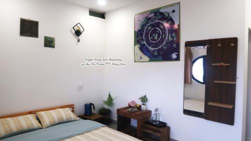 a bedroom with a bed and a mirror on the wall at Người Măng Đen Homestay in Kon Von Kla