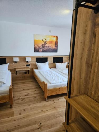 a room with two beds and a painting on the wall at Hotel & Restaurant Tanne in Fischingen