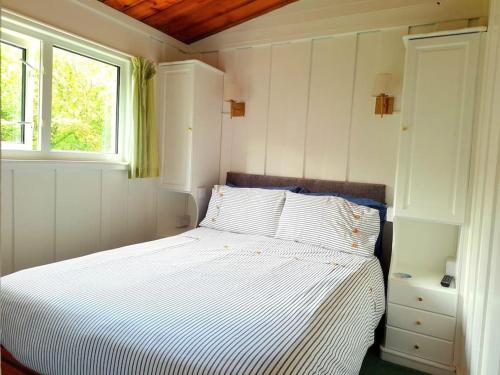 a bedroom with a white bed and a window at Kiberick Cottage at Crackington Haven, near Bude and Boscastle, Cornwall in Bude